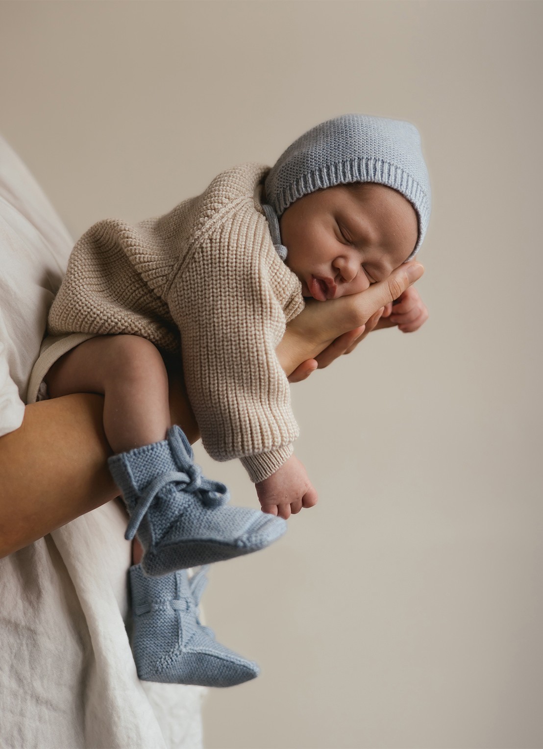 Hvid Babyslofjes van merino wol - voorkant 2 lichtblauw