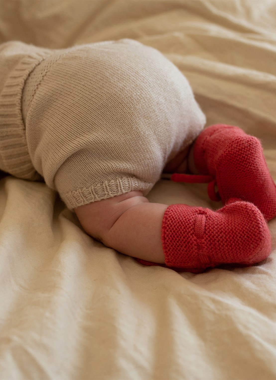 Hvid Babyslofjes van merino wol - voorkant donkerroze
