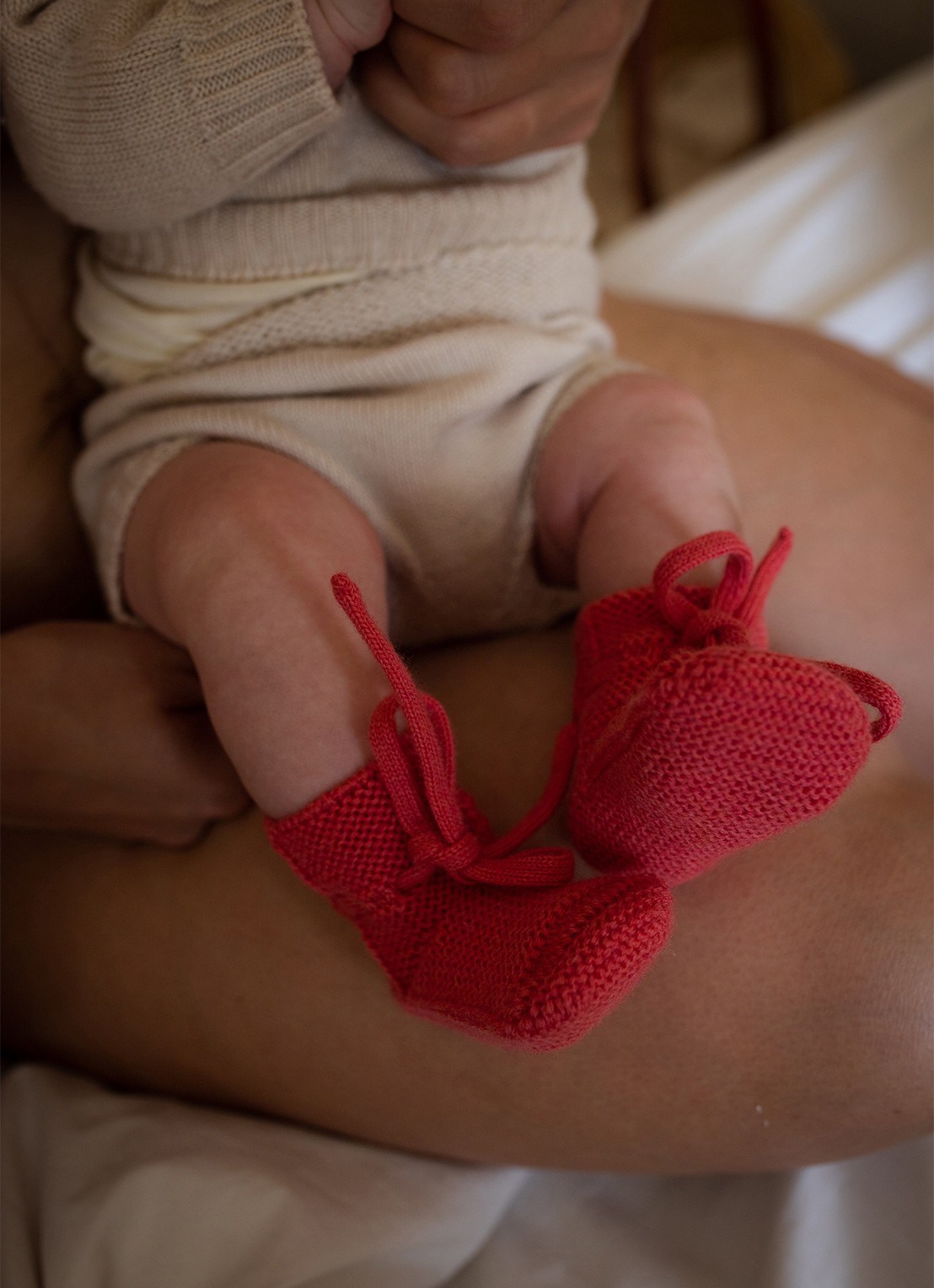 Hvid Babyslofjes van merino wol - voorkant 3 donkerroze