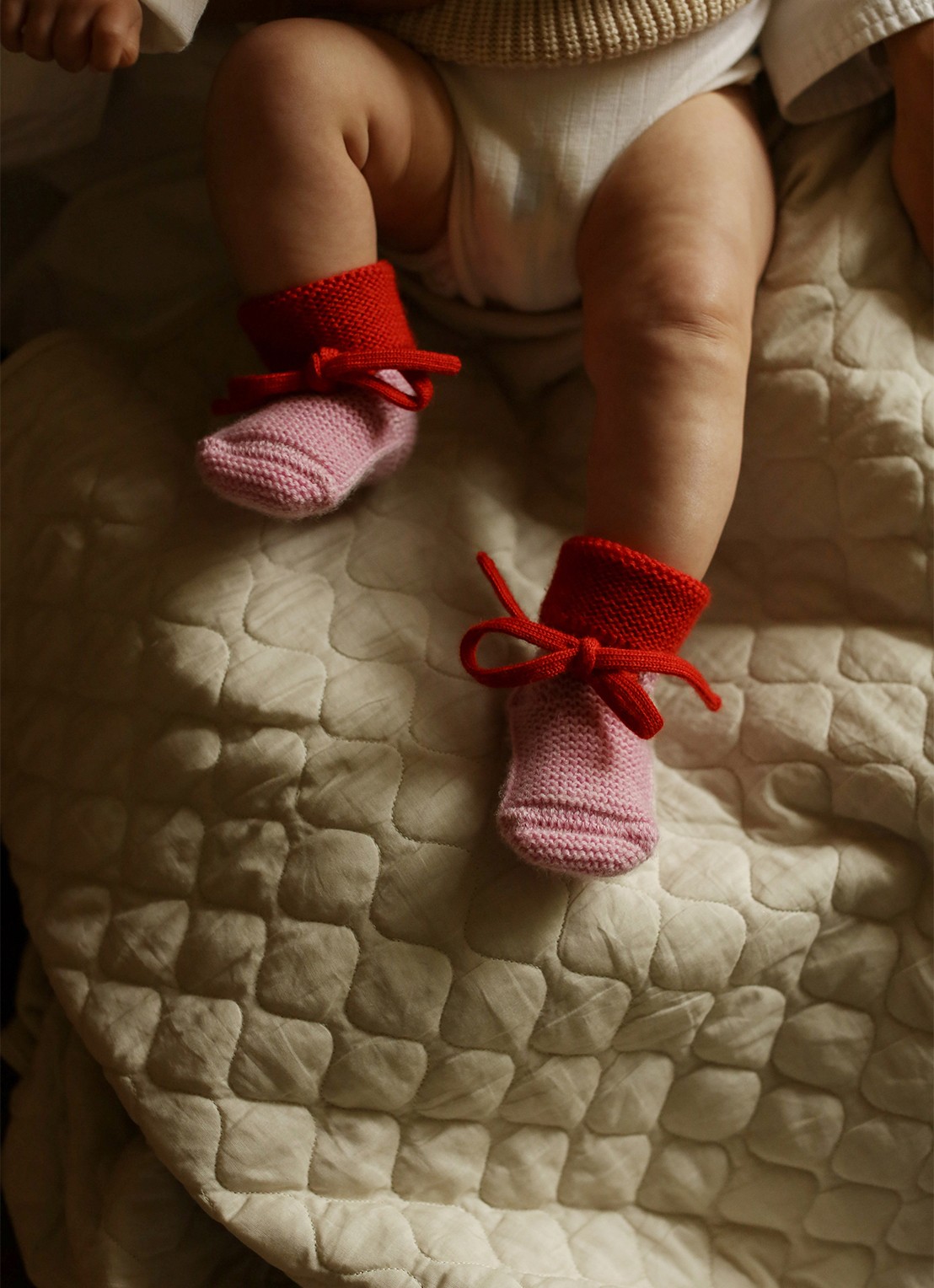 Hvid Babyslofjes van merino wol  - voorkant 2 roze