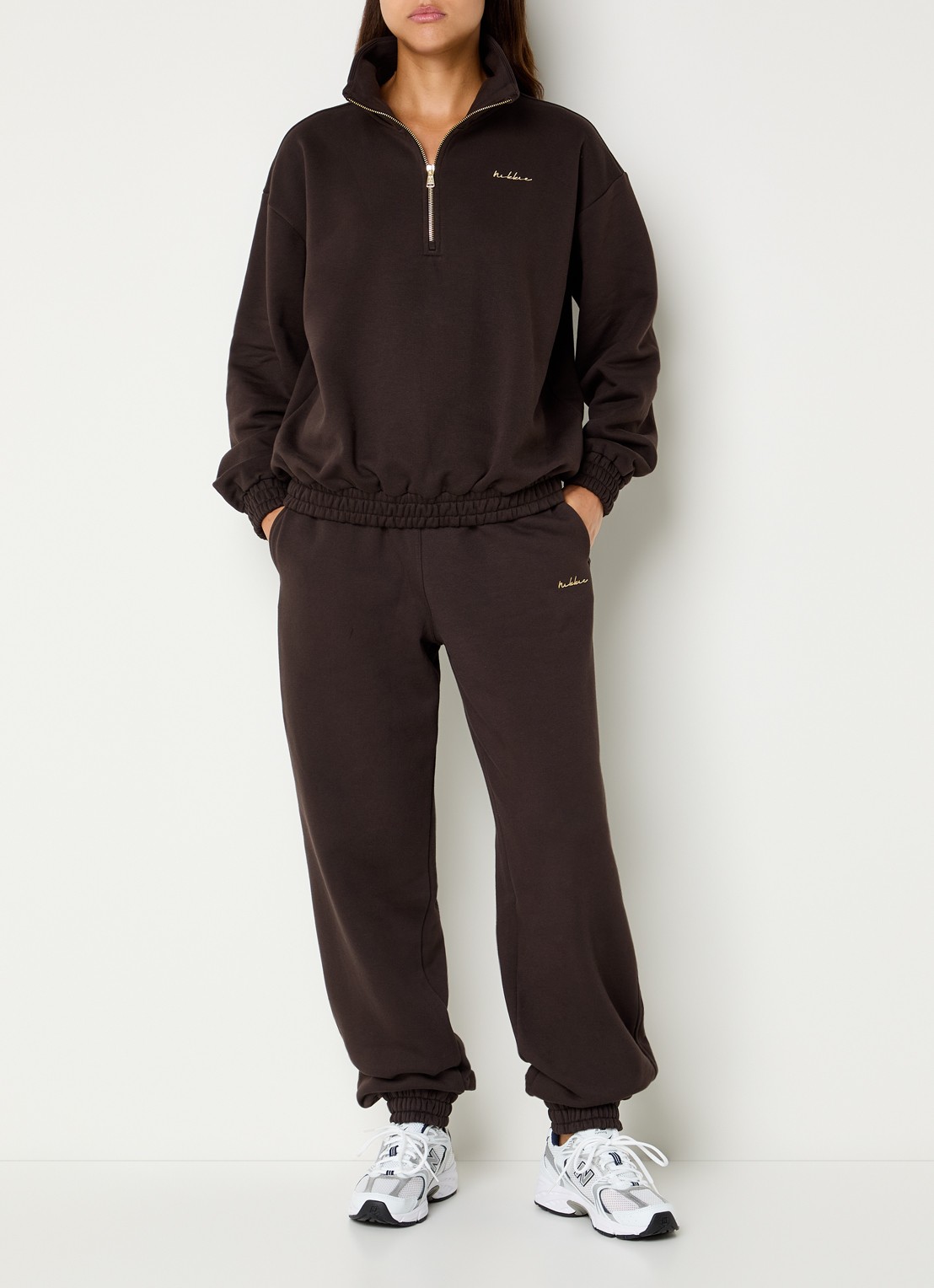 NIKKIE Avaleigh sweater met halve rits en logo - voorkant 2 chocoladebruin